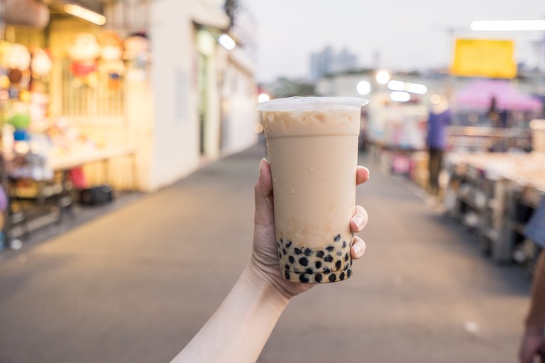 街中で大きなタピオカドリンクを手に持つ デカドリンク