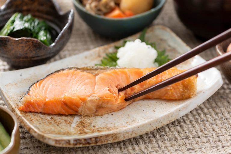 グリルで焼いた鮭の切り身。箸でほぐして食べるところ