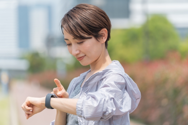 時計をチェックする女性　ランニング　マラソン