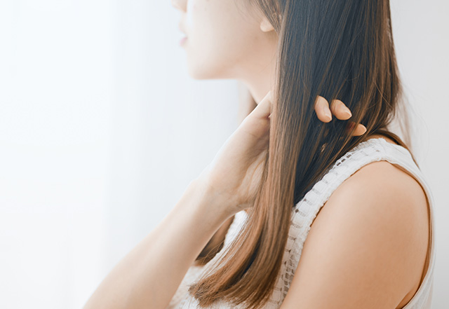 ヘアケアをする若い女性