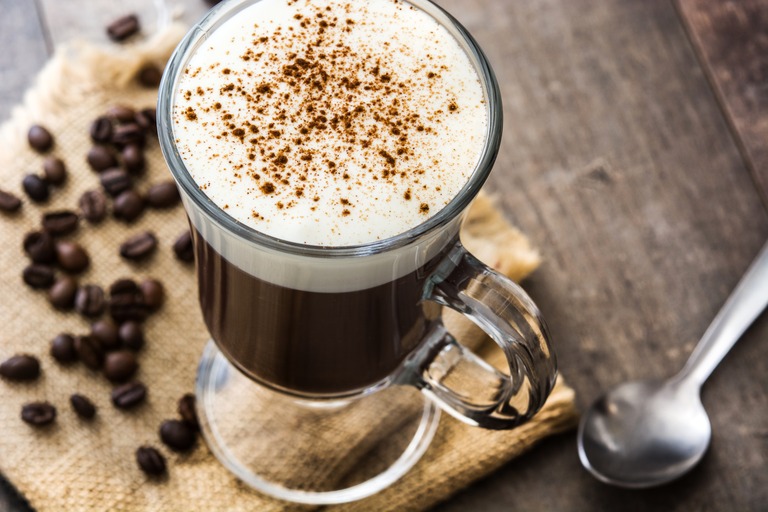ウッドテーブルの上のアイリッシュコーヒー　コーヒー袋と豆