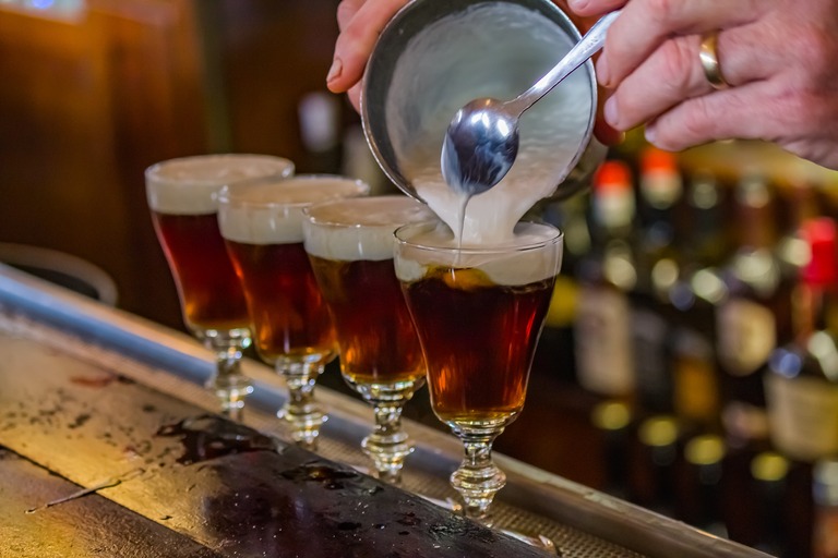 サンフランシスコの有名なブエナ・ビスタ・カフェで飲むアイリッシュコーヒー　生クリームを入れている