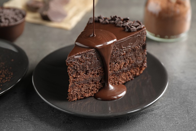 チョコレートケーキに溶かしたチョコレートをかける様子